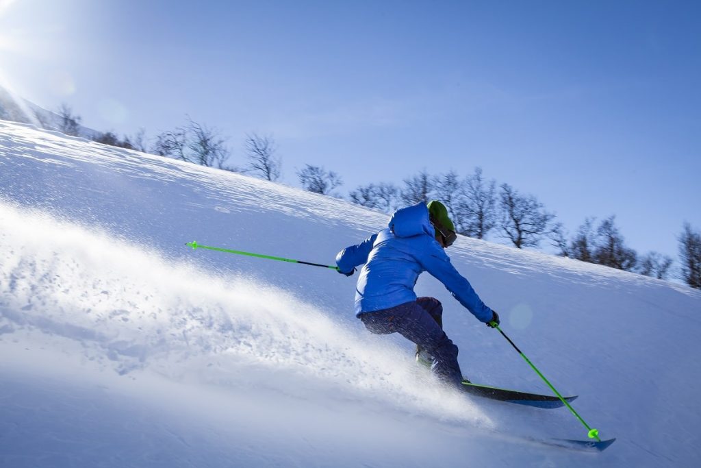 Skiing-downhill-in-blue-jacket