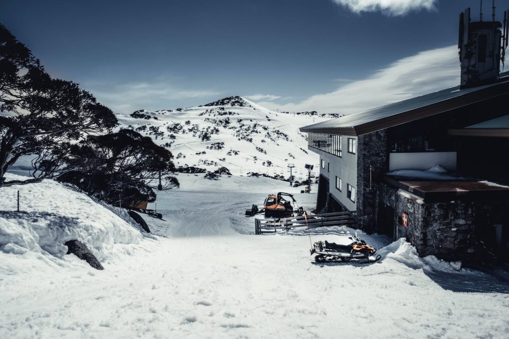 a snowmobile parked in front of a building in the snow